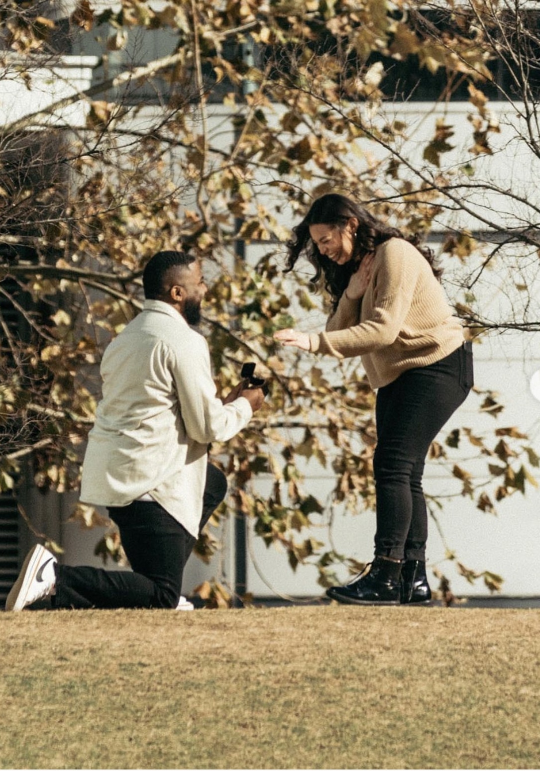 A man gets down on one knee to propose to a woman at Discovery Green in downtown Houston