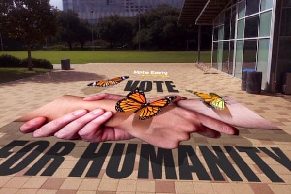Two hands with butterflies are depicted in a 3D chalk mural