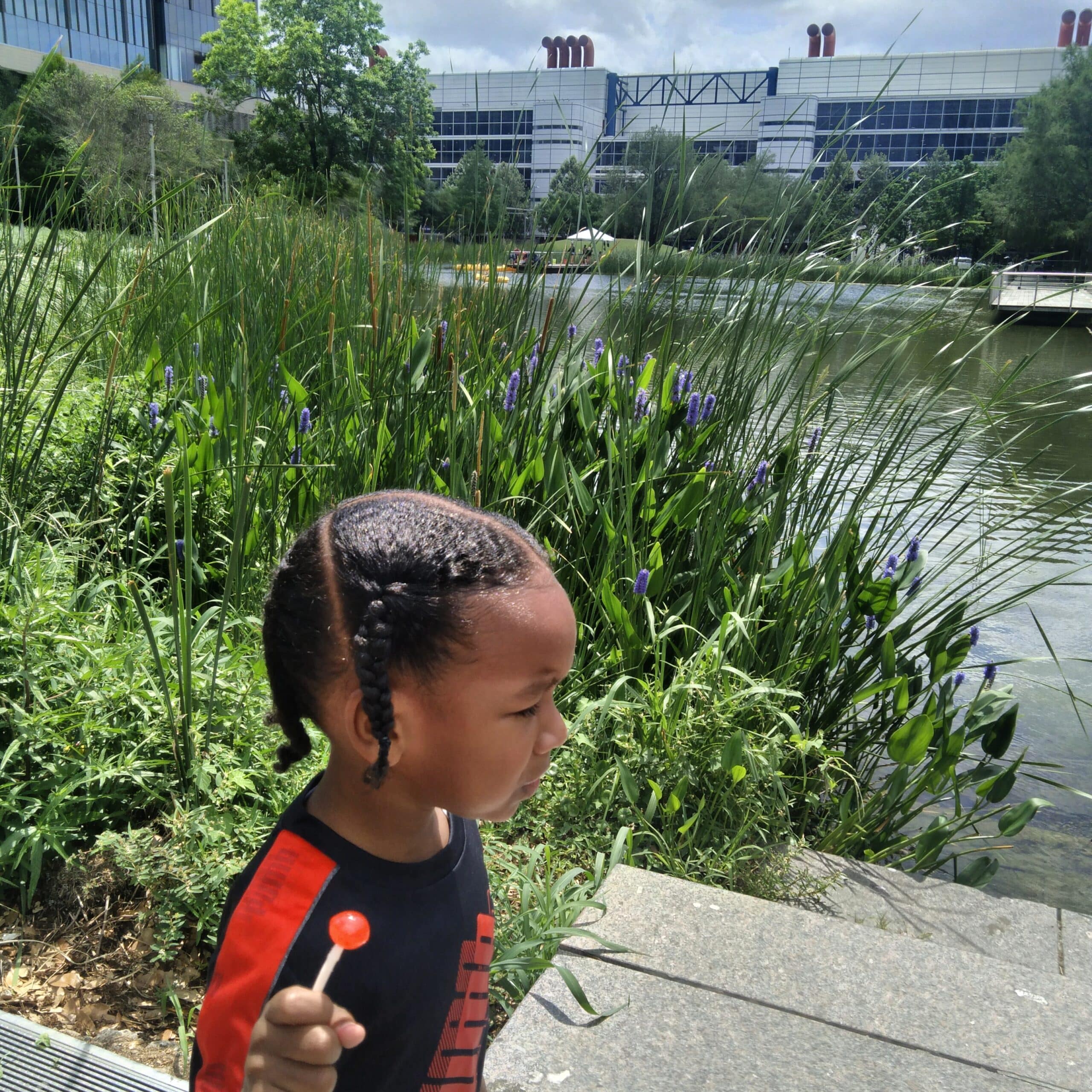 A little boy walks by Kinder Lake in downtown Houston at Discovery Green