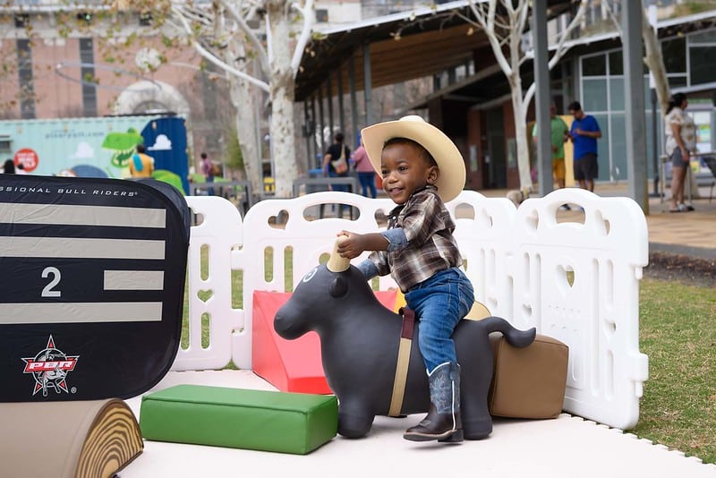 The cutest little cowboy toddler enjoying a toddler event at Discovery Green in Downtown Houston.