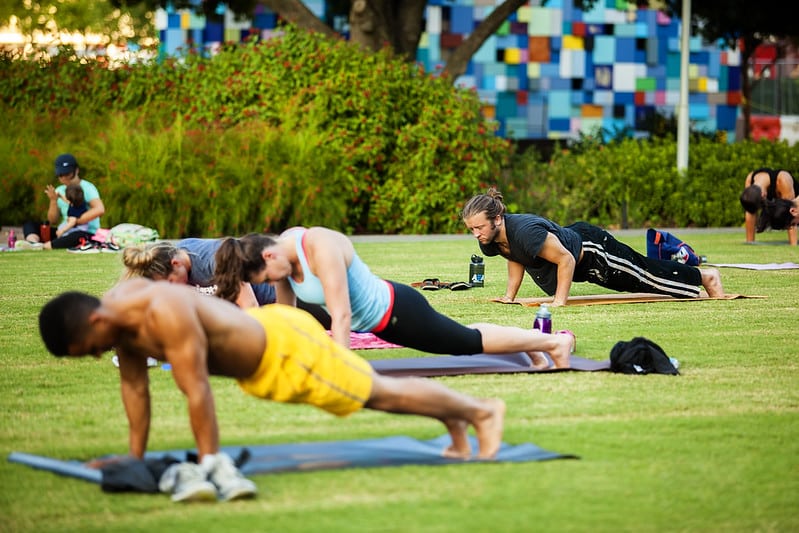 A group of people enjoying Hatha Yoga in the Park at Discovery Green in Downtown Houston