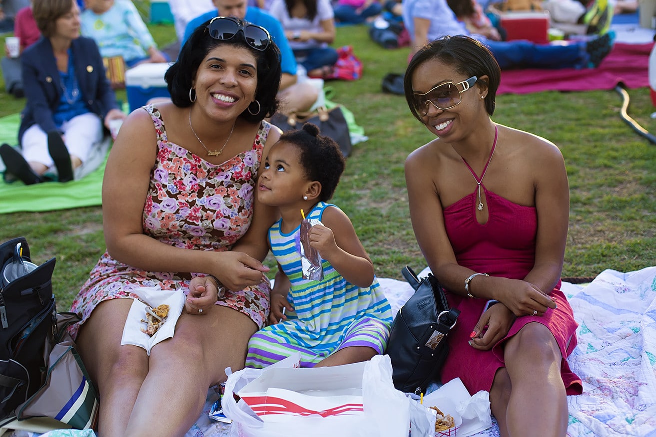 A family enjoys a concert at Discovery Green in downtown Houston