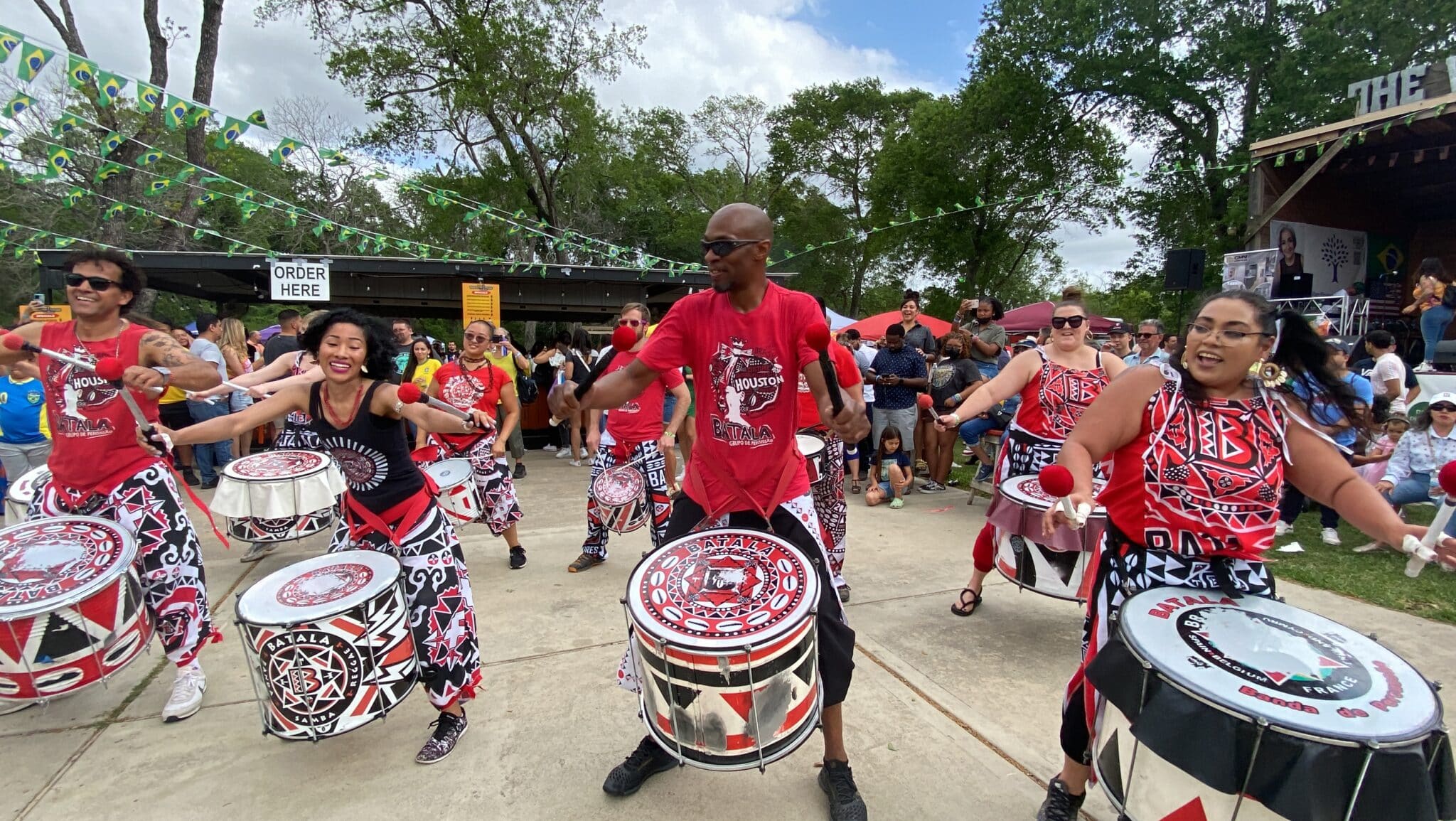 Musicians dance and play the drums. Batalá Houston is a percussion group that is part of a worldwide percussive movement called Batalá Mundo.