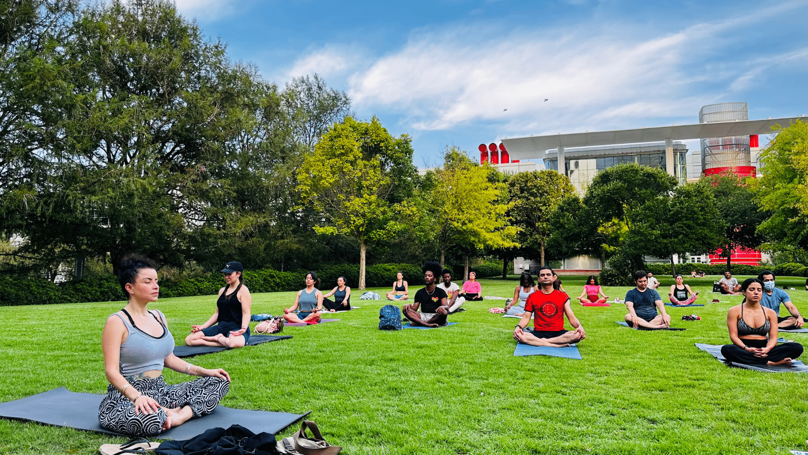 Yogis practicing yoga on a green lawn at Discovery Green in Downtown Houston