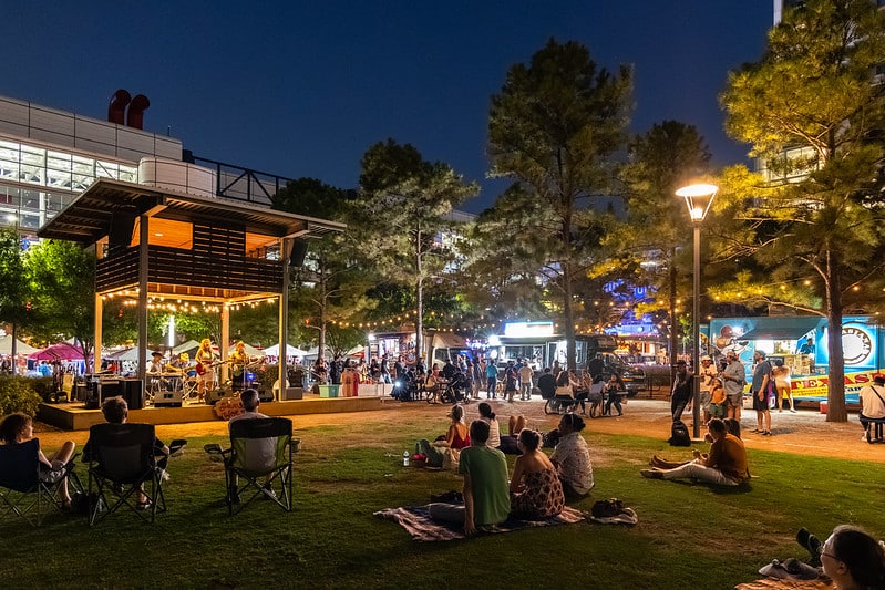 Flea market in the middle of Downtown Houston with people enjoying vendors, live music, and food trucks