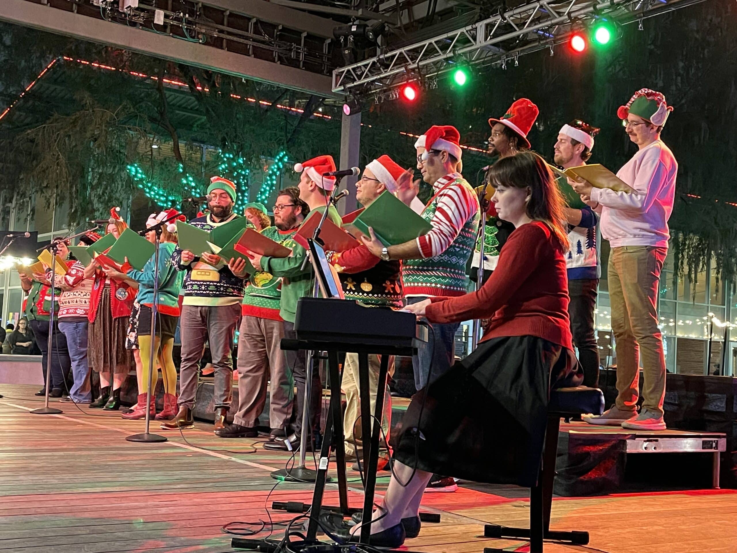 Carols on the Green event - carolers on stage performing in holiday attire