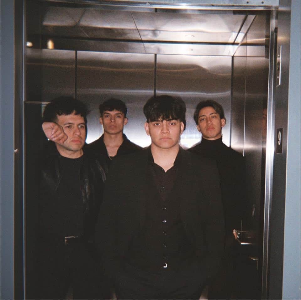 The four members of the band Vortxz stand in an elevator for a promotional photo